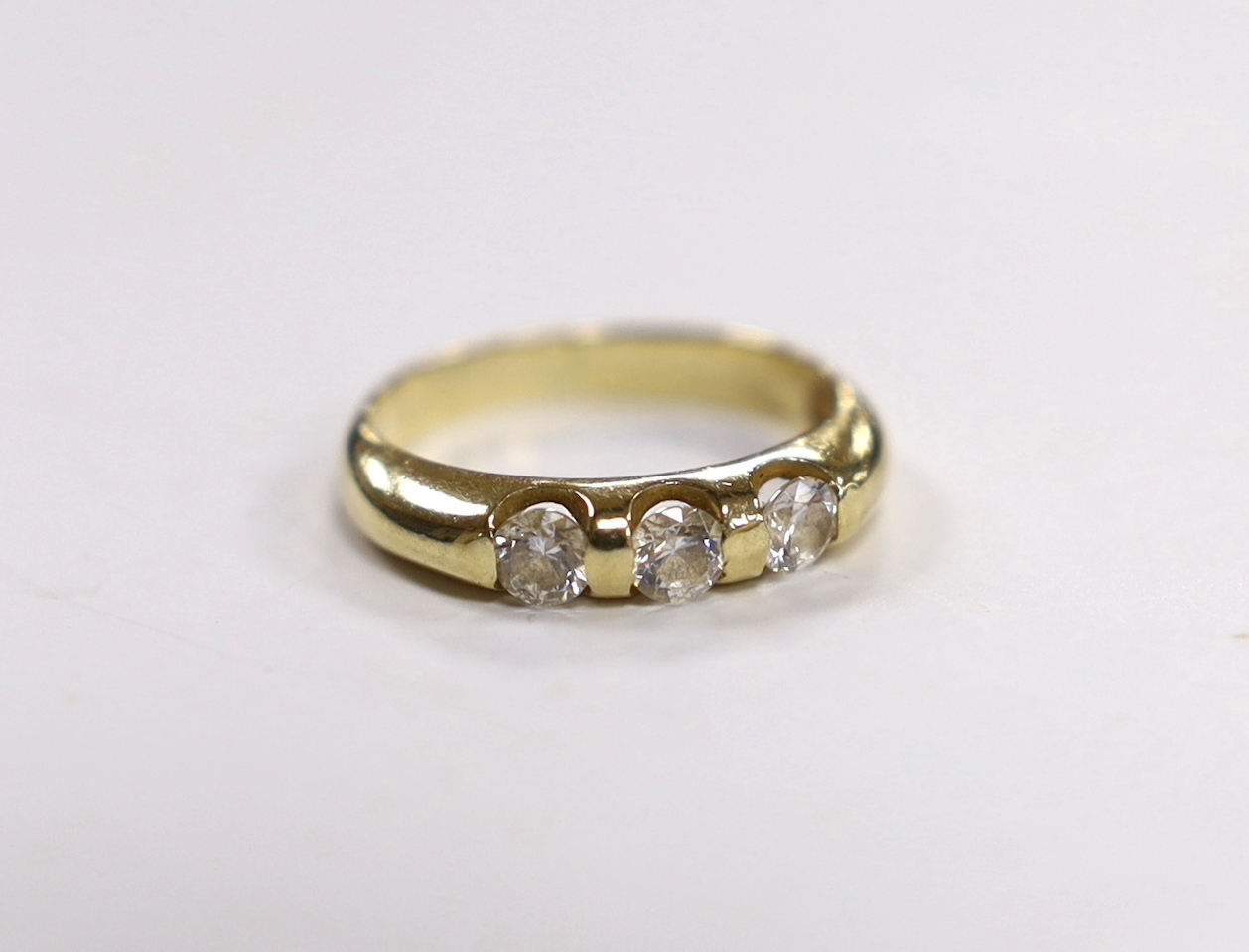 A yellow metal and three stone simulated diamond set ring, size K, gross weight, 2.7 grams.